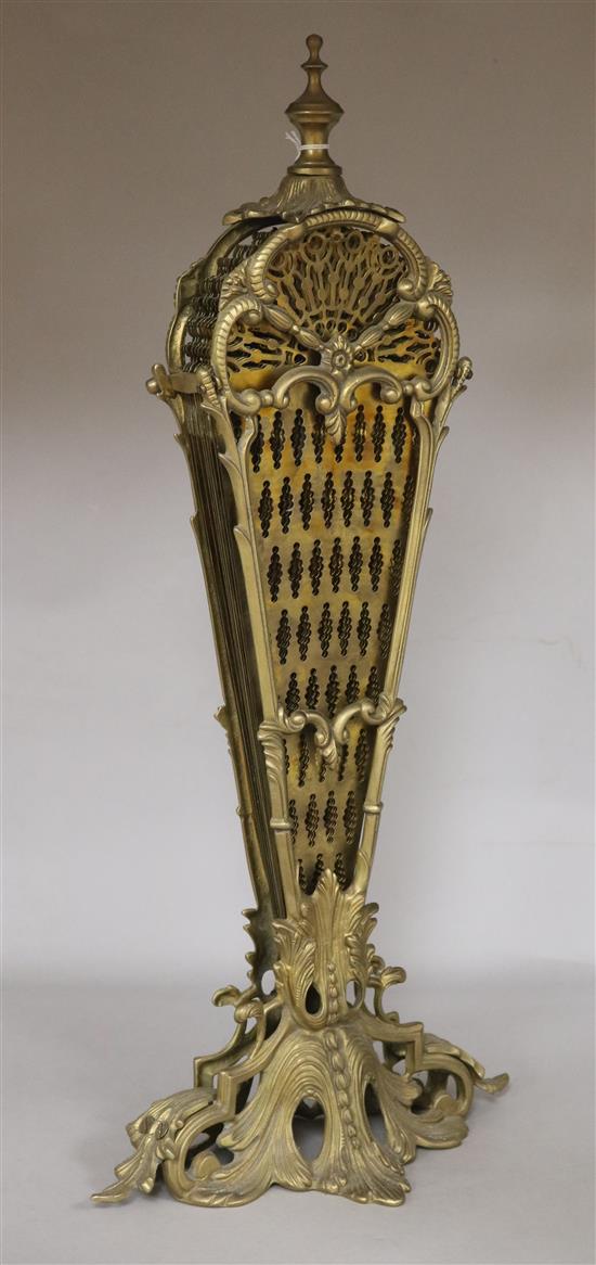 A fan shaped brass fire screen